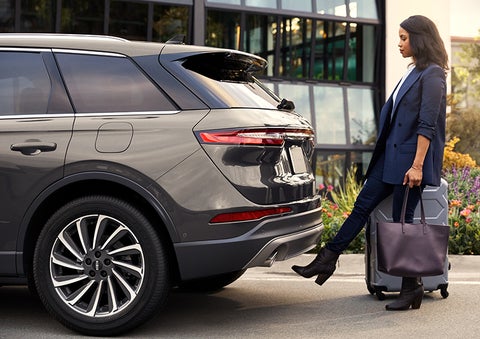A woman with her hands full uses her foot to activate the available hands-free liftgate. | Magic City Lincoln in Roanoke VA
