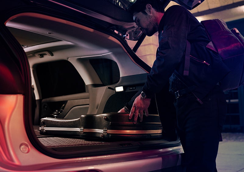 A man is shown loading cargo into the rear of a 2024 Lincoln Corsair® SUV with the second-row seats folded flat. | Magic City Lincoln in Roanoke VA