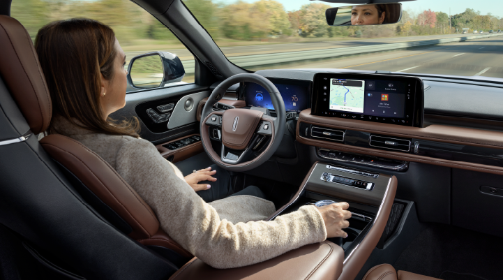 A woman is seen sitting in the driver’s seat of her 2025 Lincoln Aviator® SUV with her hands off the steering wheel. | Magic City Lincoln in Roanoke VA