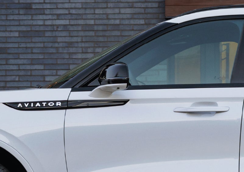 The driver’s side door and fender badging of a white 2026 Lincoln Aviator® SUV are showcased. | Magic City Lincoln in Roanoke VA