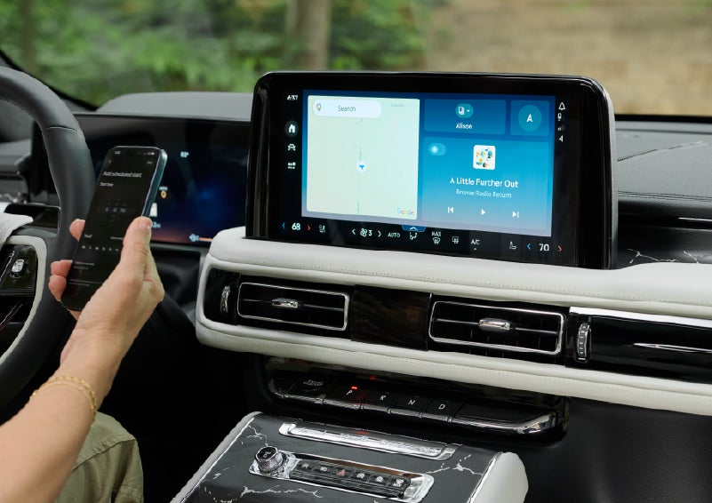 A person pairs thier phone with the center touchscreen of a 2027 Lincoln Aviator® Black Label™ SUV | Magic City Lincoln in Roanoke VA